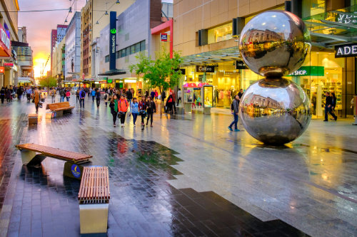 People walking along the Rundle Mall at sunset